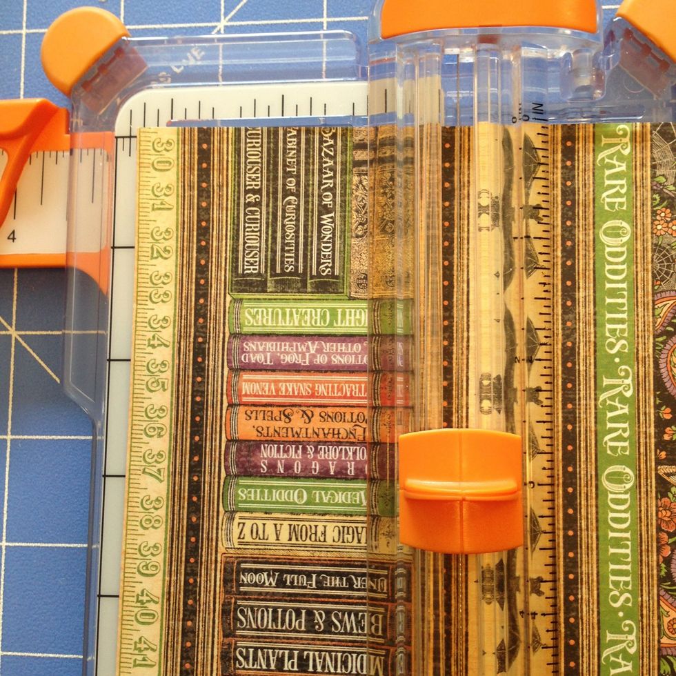 Cut 1 strip of paper measuring 2 1/4"x 5" from the "Brews and Potions patterned paper.   Cut the row that had the books and include the black line on either side.