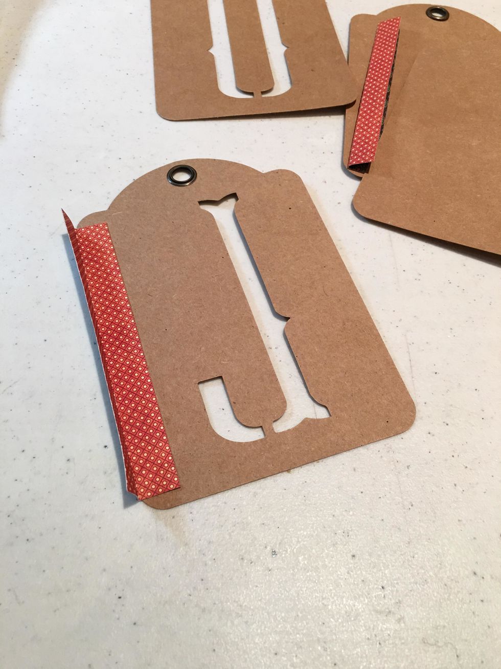 Cut 1" wide strips of patterned paper just a tad shorter than the height of the tags, fold and score in half lengthwise. This will create the hinges to attach the tags together to create your album.