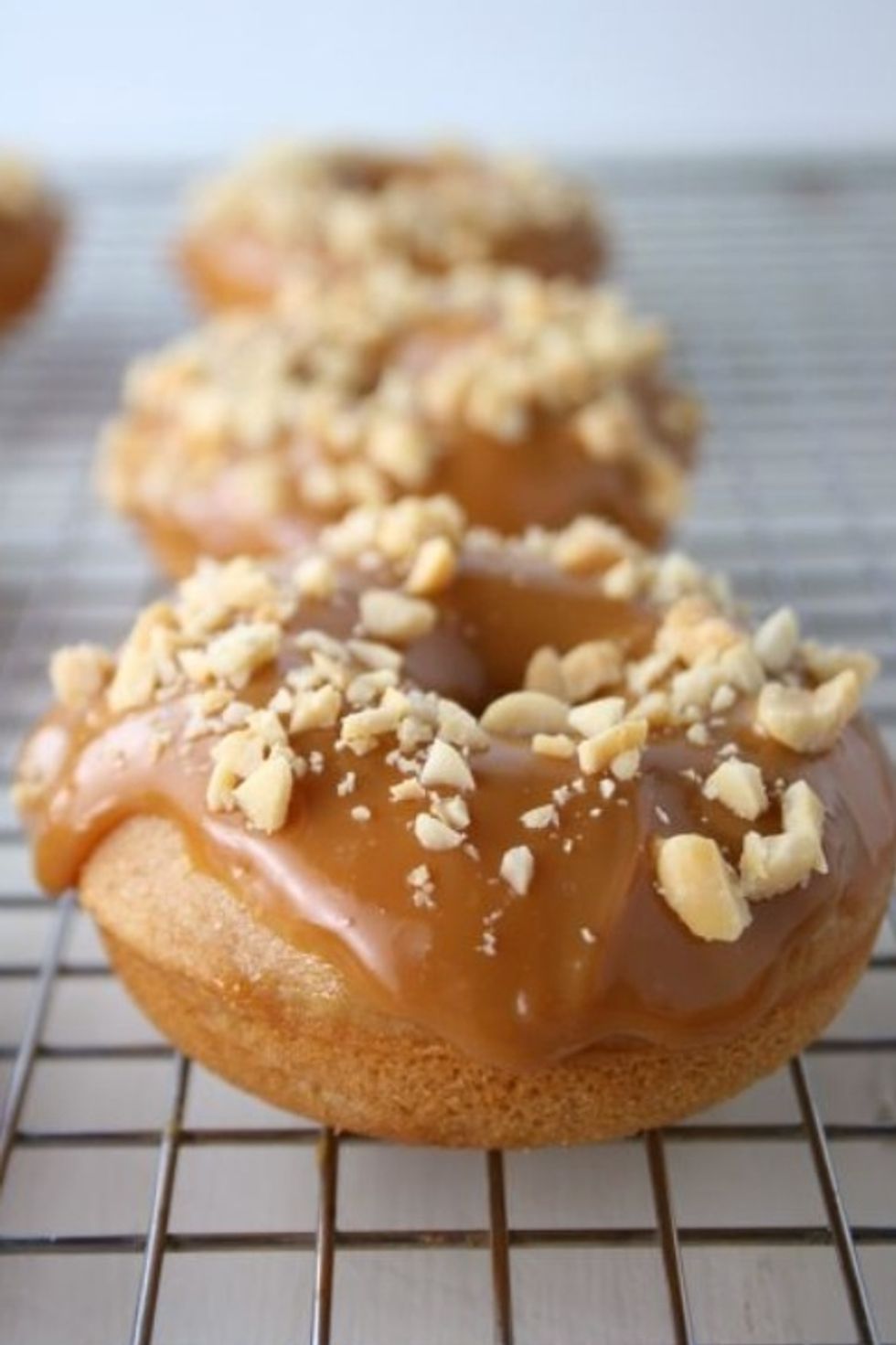 Cut 2 slits in the side of the donuts then with a piping bag fill then with whipped cream. Dip the donuts in the caramel mixture then sprinkle on the nuts. Delicious !!!!