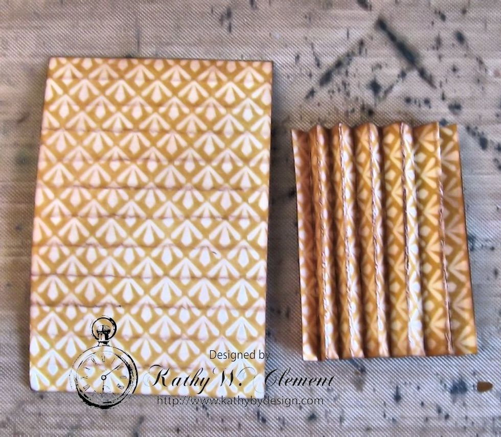 Cut 2 strips of Mind Over Matter paper to measure 2" wide x 3" tall.  Score at 1/4" intervals and accordion pleat.  Ink all edges.  These will allow you to create an accordion pocket on your tag base.