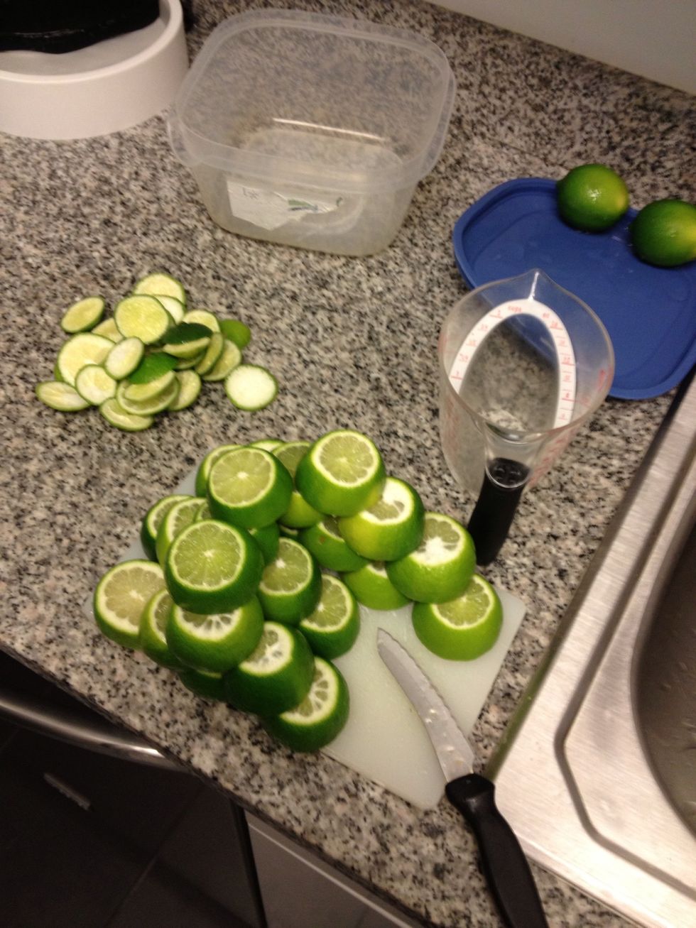 Cut 20-28 Limes. Start by removing ends to expose inner part of lime, then cut down the middle between both ends.