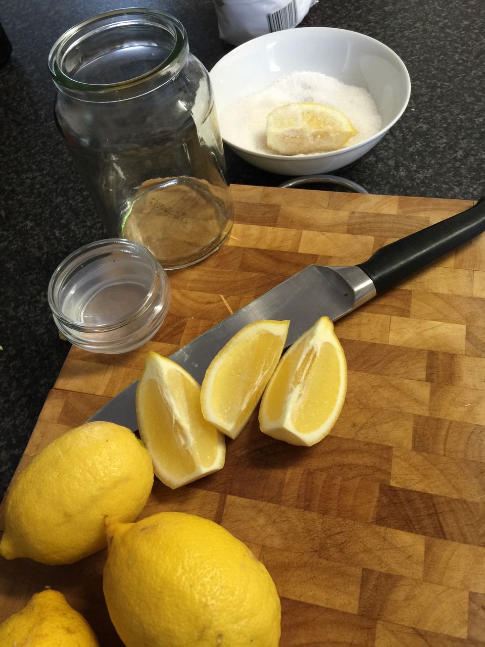 Cut 3 lemons in quarters, coat liberally in salt and place into a jar. Continue until lemons are all in jar and squish down firmly.