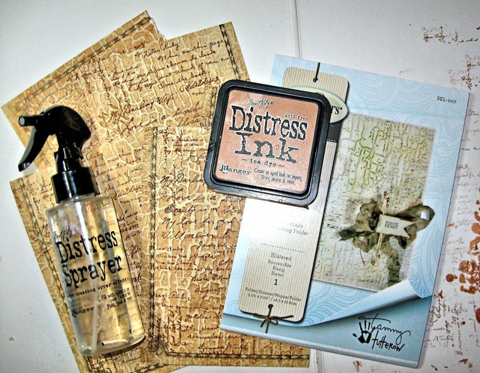 Cut 4 pieces of stamped paper to 5" x 7". Spritz lightly with water. Rub Tea Dye on flat side (debossed side) of folder. Place paper on raised side (embossed side). Run thru die cut machine.