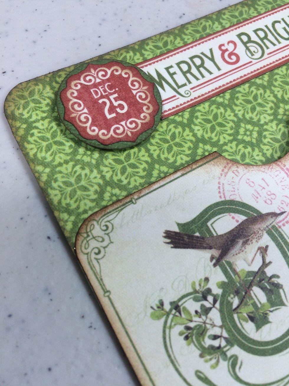 Cut a 1" circle from green cardstock. Layer the Dec. 25 piece onto it. Then adhere this unit plus the Merry & Bright strip across the top of the card. I used foam tape to pop up the circle.