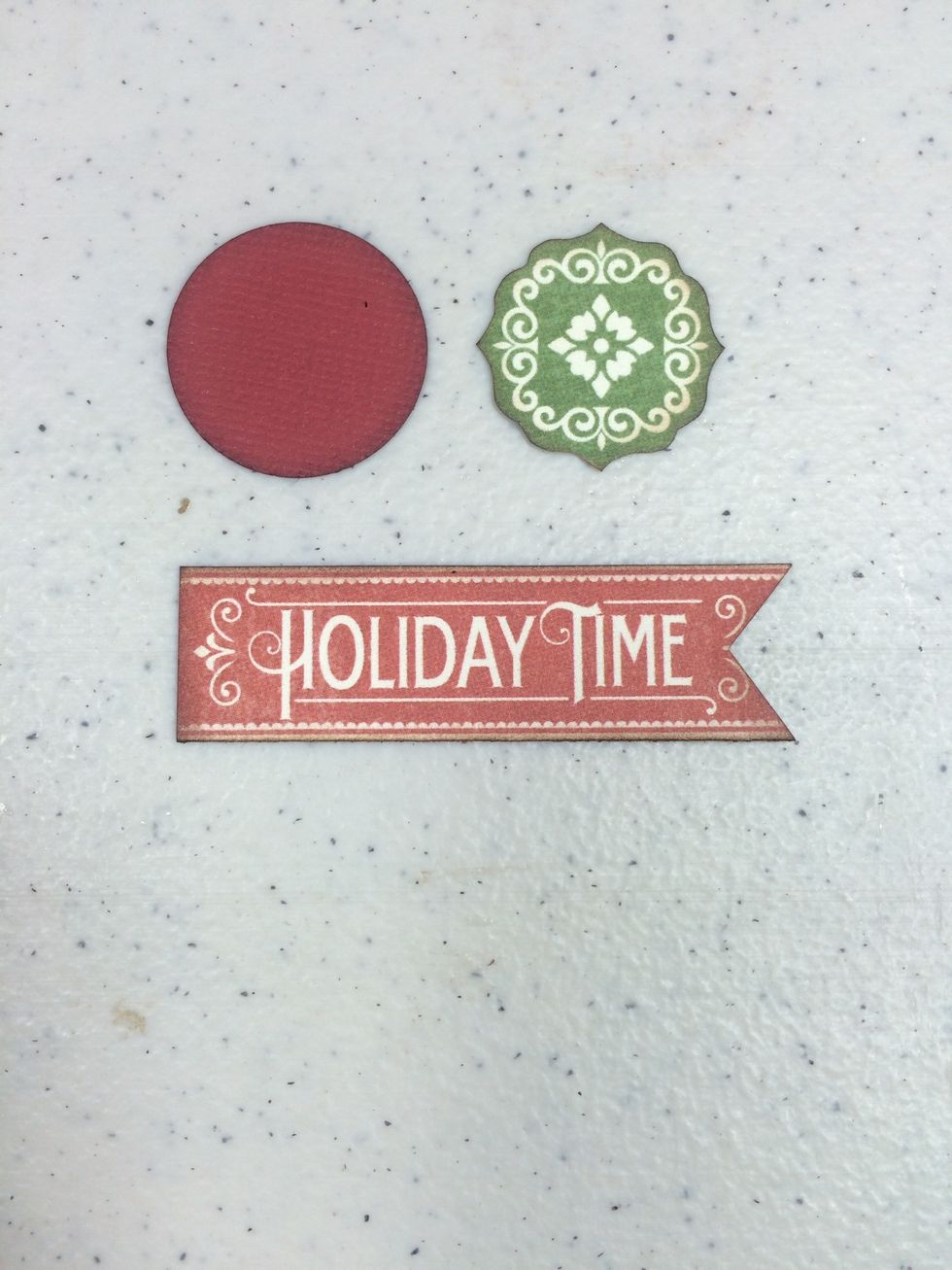 Cut a 1" circle from the red cardstock. Cut around the green medallion piece and adhere to the circle. Cut a v-notch off the right end of the Holiday Time strip. Ink edges.