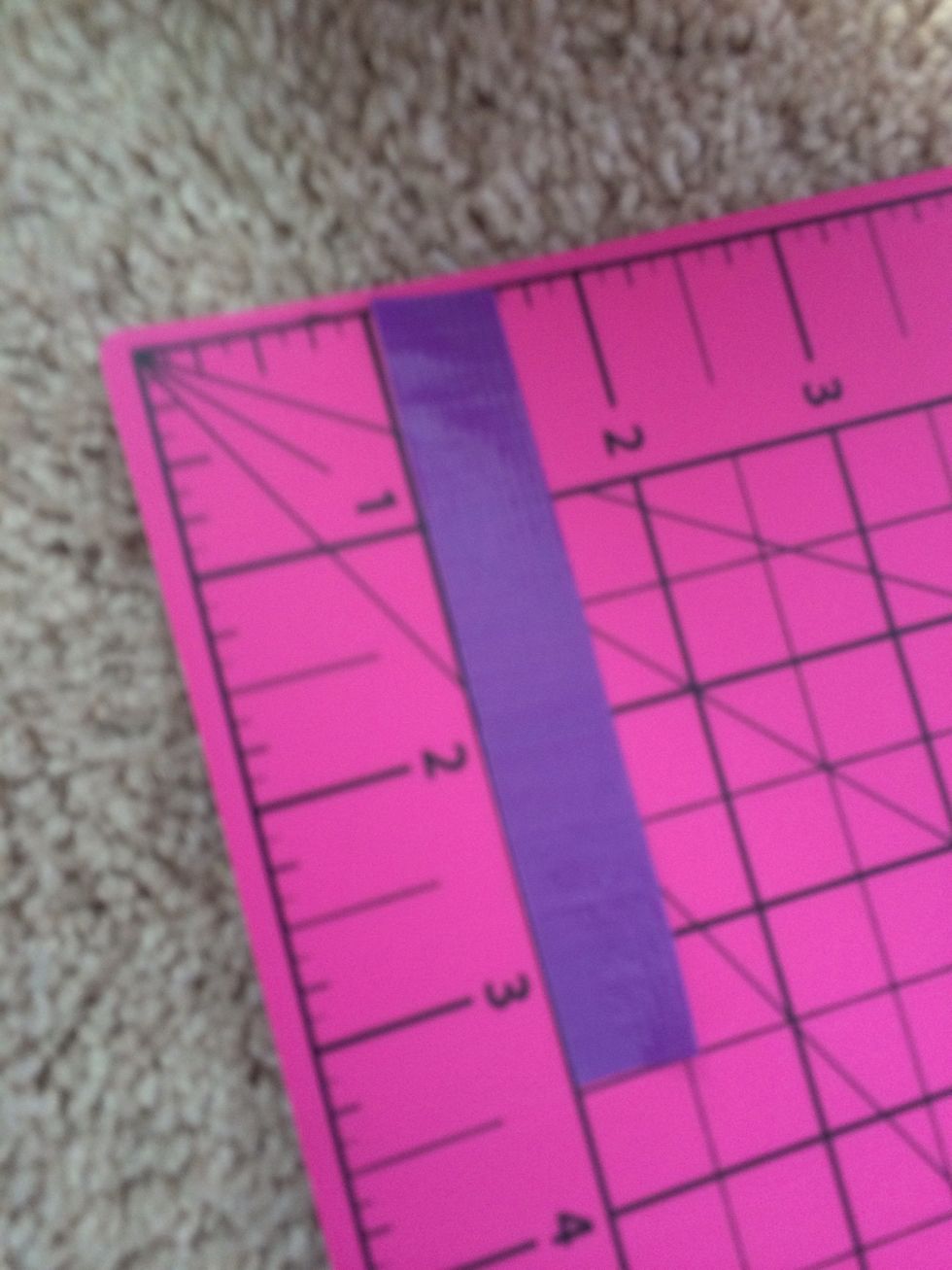 Cut a 3.5 inch piece of colored duct tape and tape it on the bottom of the second pocket.