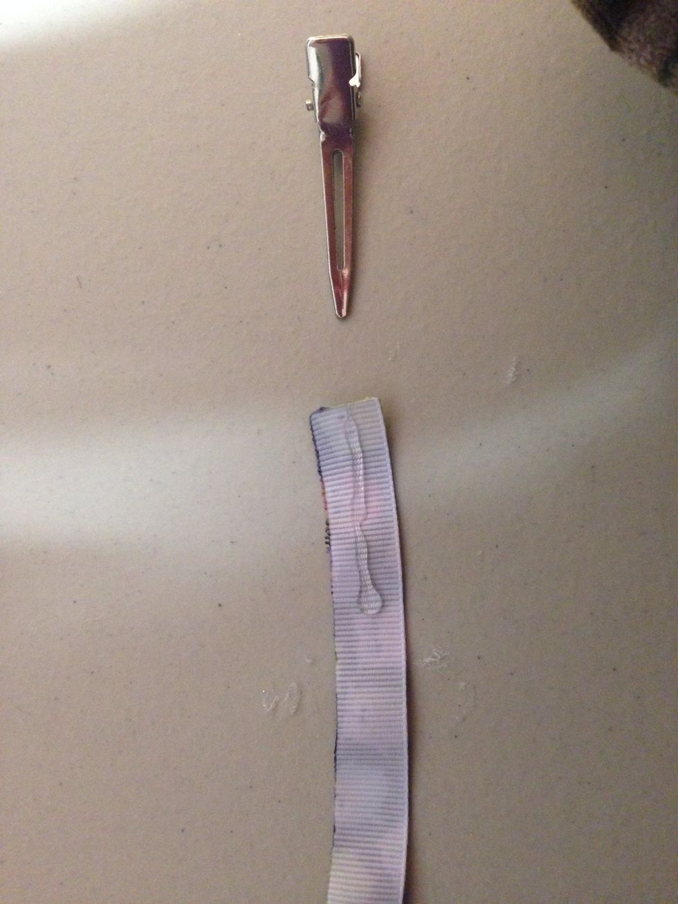 Cut a 3/8 inch piece of ribbon and heat seal. Then put some glue on the end and slip it on the alligator clip