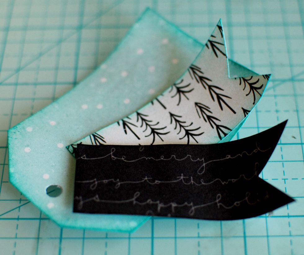 Cut a 3\u201d tag from the Workshop Sheet. Punch a hole in the top, and ink the edges. With the rectangles, cut triangles out of one side of each. Punch a hole at the square end.