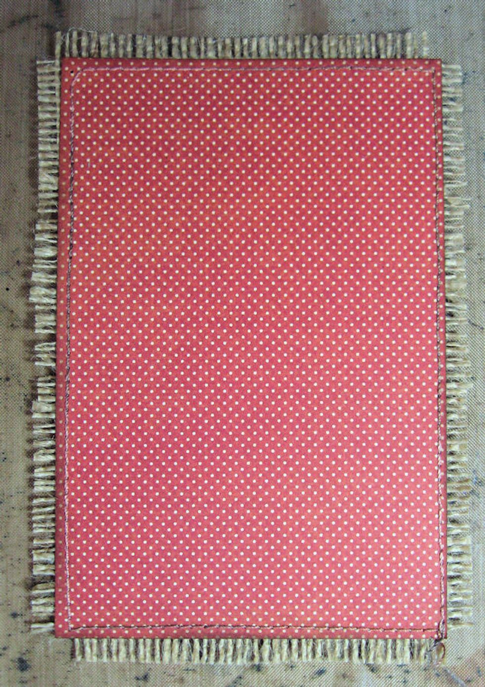 Cut a 4" x 6" panel of red dot paper from prints & patterns. Machine stitch onto a slightly larger piece of natural burlap. Fringe edges & trim. If you do not want to sew, just glue paper to burlap.