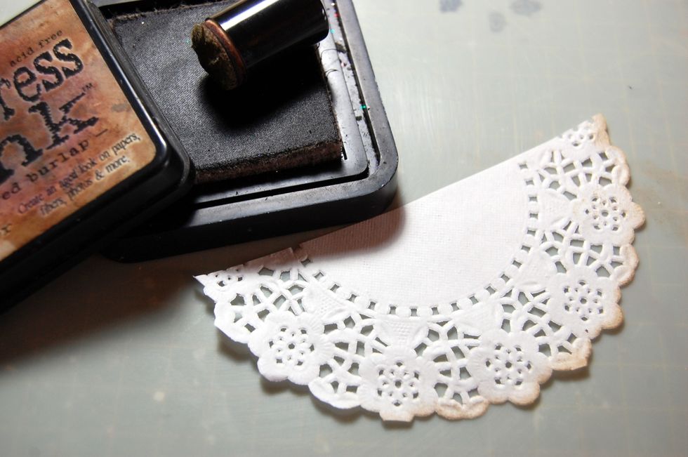 Cut a 5" doily in half and ink the edge with some Frayed Burlap distress ink. At the same time ink around the edges of the plaque.