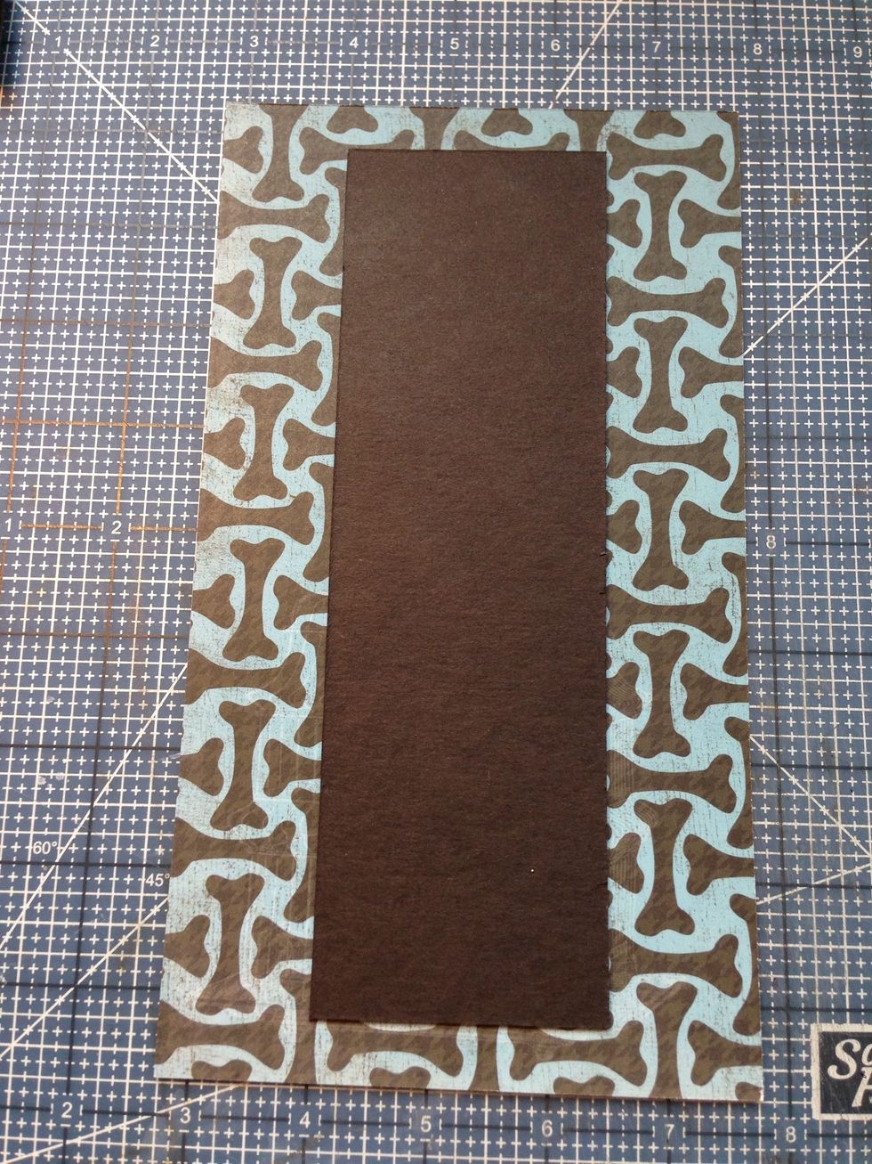 Cut a 5" x 9" pieces of patterned paper for outer spine cover. Attach spine chipboard centered on paper.