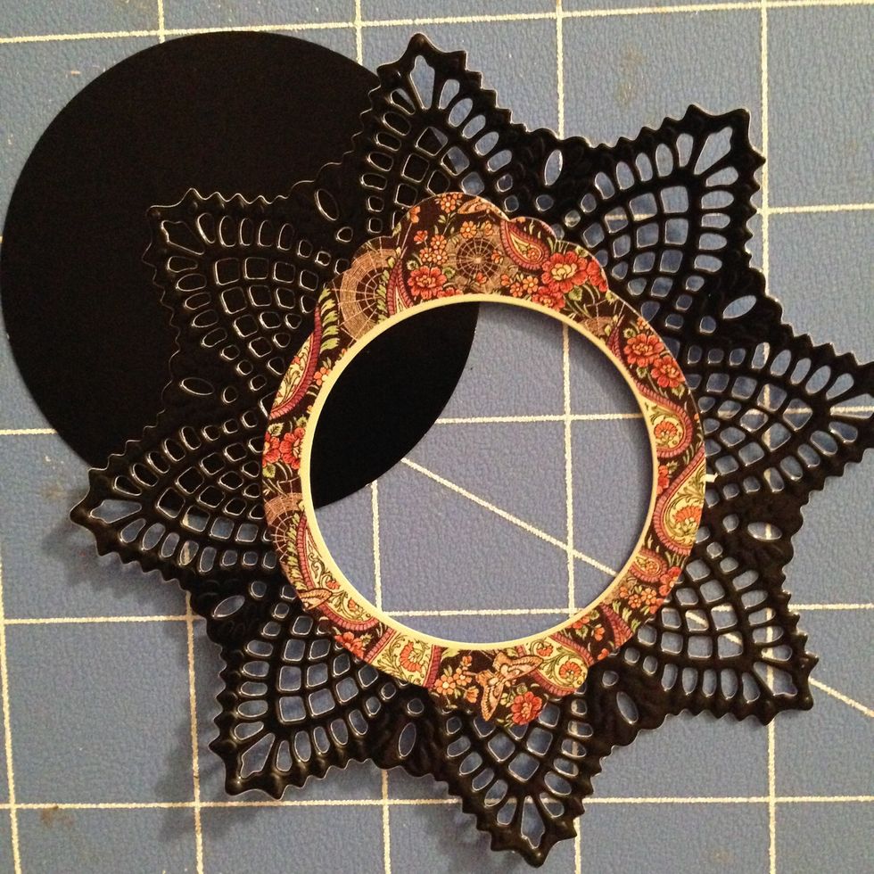 Cut a circle from the black shiny paper.