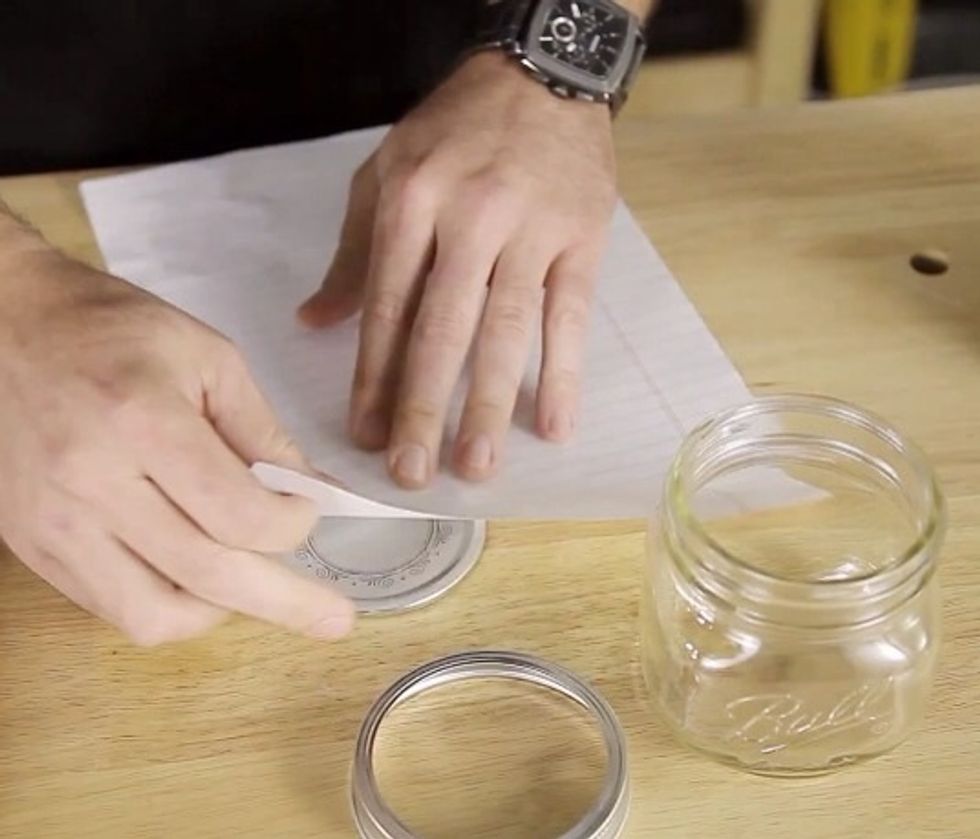 Cut a circle out of the sandpaper to fit right over the Mason jar lid. Trace the scratch paper over the jar using scratch paper, and cut that out.