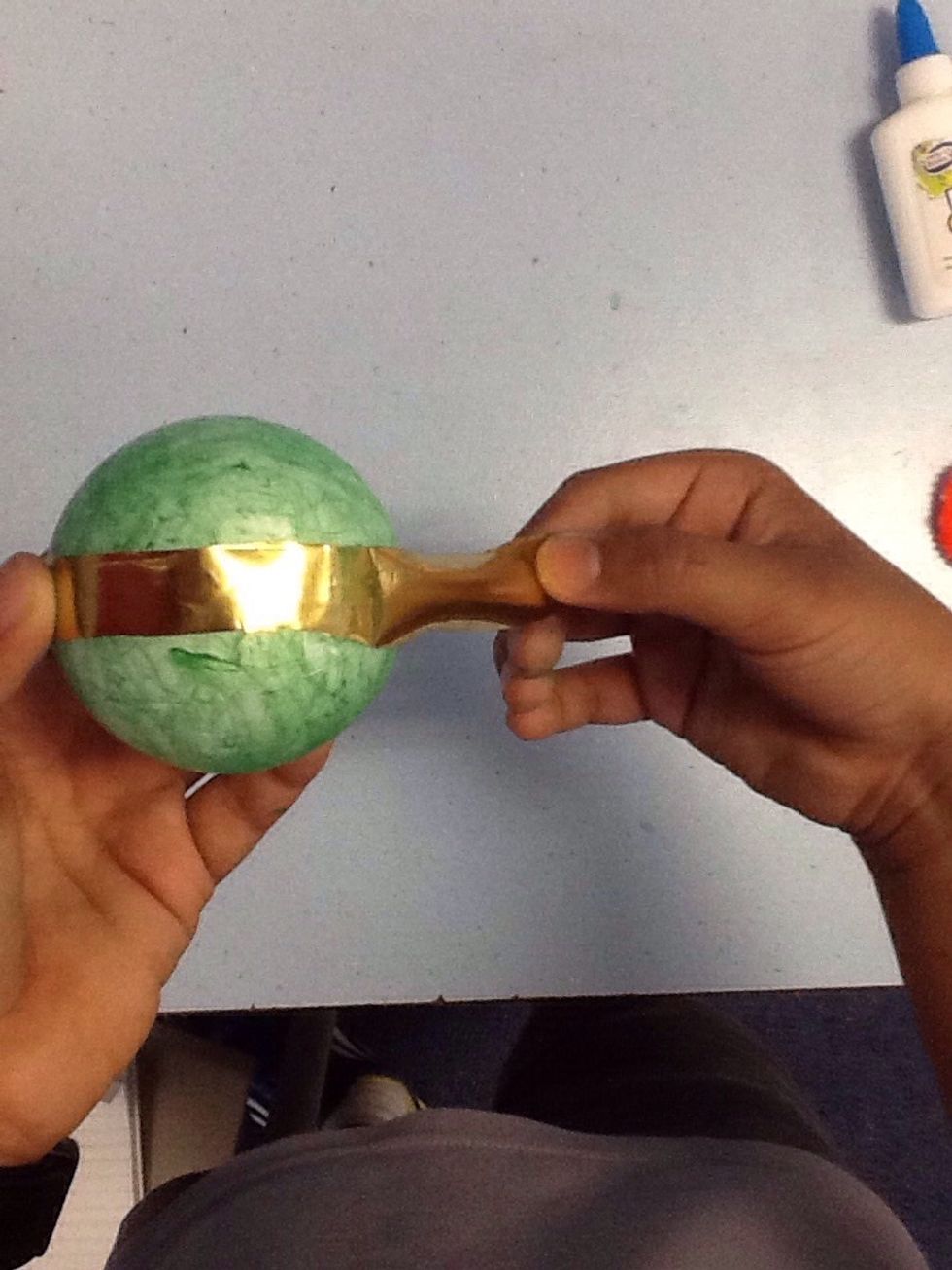 Cut a golden strip and round it around the foam ball.