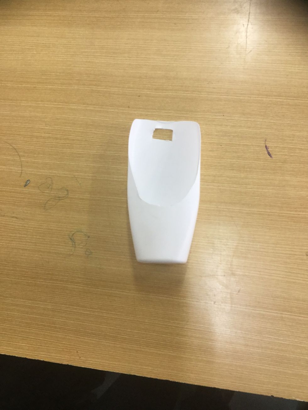 Cut a holes of that the charger tongs only just fit so that the phone charger hangs from the charger.