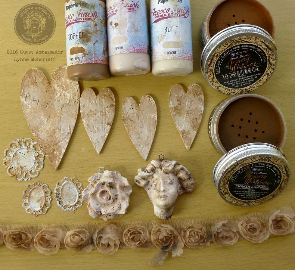 Cut a length of lace rose trim so that it will cover the large heart. Scatter some Artisian Powders Parthenay & Chapeliere onto the trim, misting with water for a distressed effect. Leave to dry.