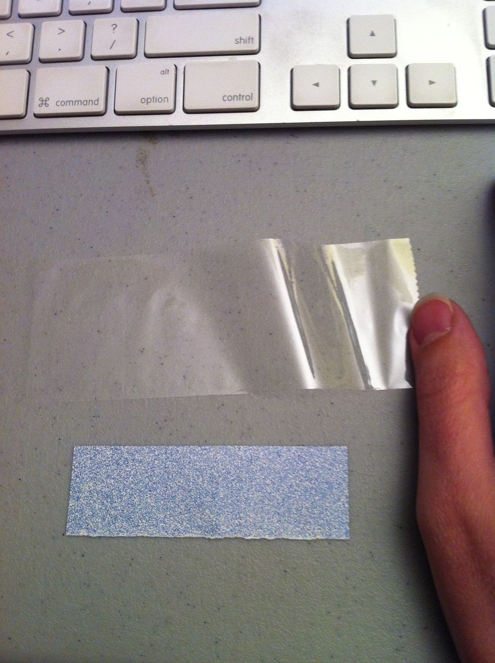 Cut a length of tape a bit longer than your paper bit, and lay it sticky side up.