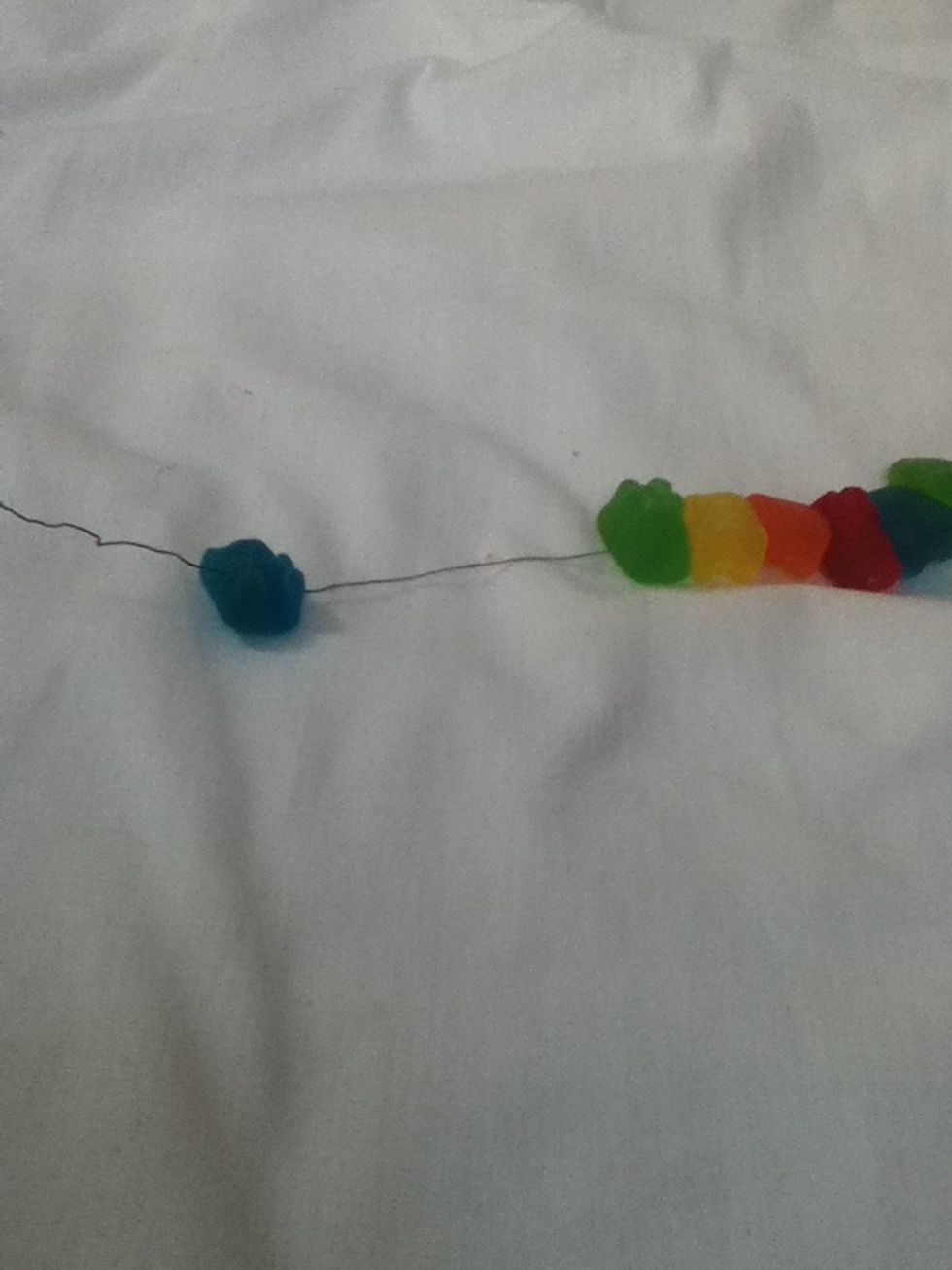 Cut a length of wire that fits your neck, with some room to tie and loose enough so it doesn't choke you.Slide a gummy bear onto the wire and repeat the step until you finish.
