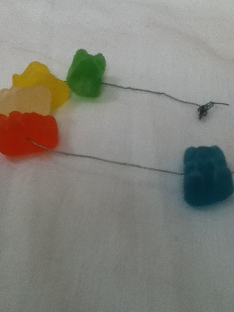 Cut a length of wire that fits your wrist. Slide a gummy bear onto the wire and repeat till it's done.