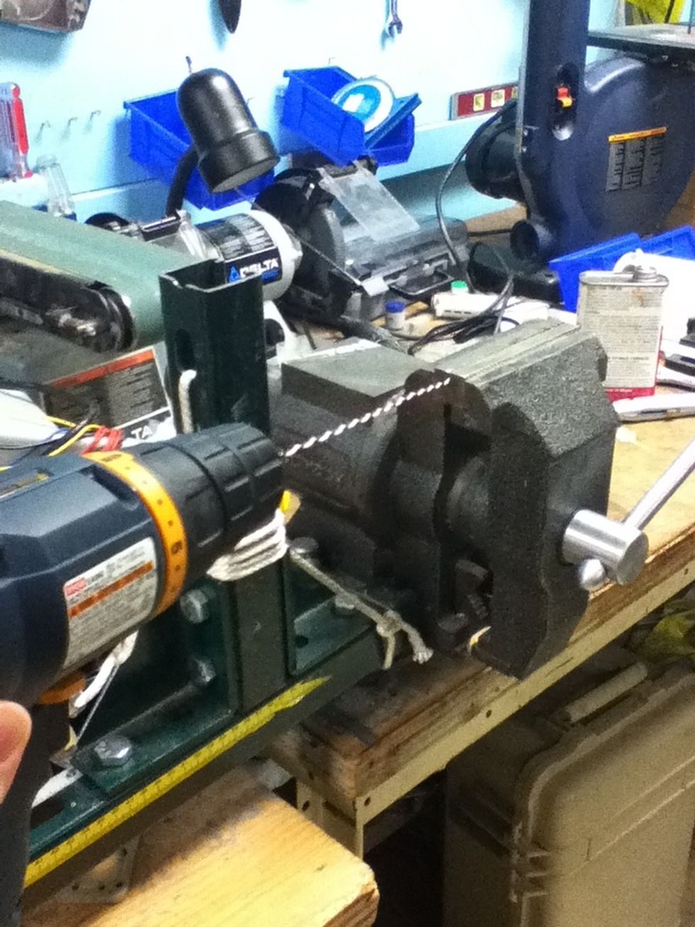 Cut a long length of black and white wire. Pinch one pair of ends in a drill and the other pair in a vise. Twist the wires tightly.