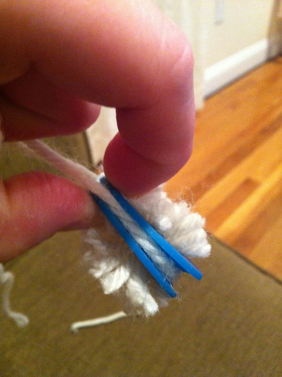 Cut a new long(ish) length of yarn and wrap between the two discs as shown. Tie tightly and pull apart discs.