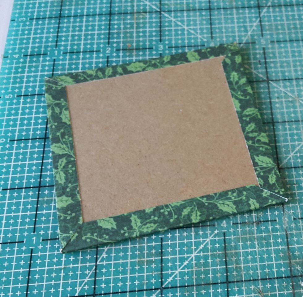 Cut a piece of chipboard of 3-5/8"x3-5/8", cover with pattern paper of 4-1/8"x4-1/8", fold the excess and adhere well