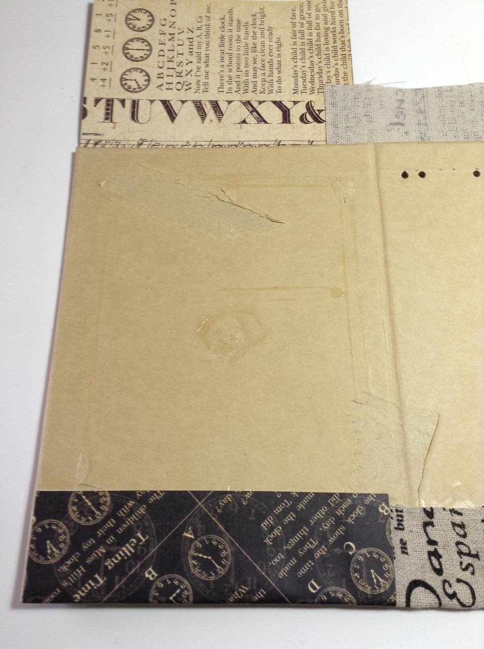 Cut a piece of paper and use adhesive to adhere it to the exterior cardboard .