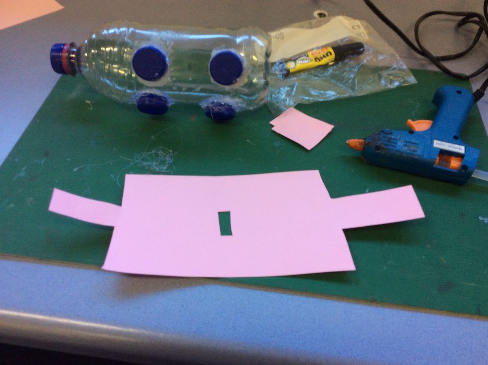 Cut a piece of piece of pink paper so it can fit around your piggy bank.