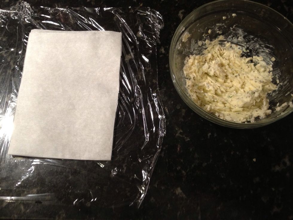 Cut a piece of plastic wrap and top with a smaller piece of parchment.