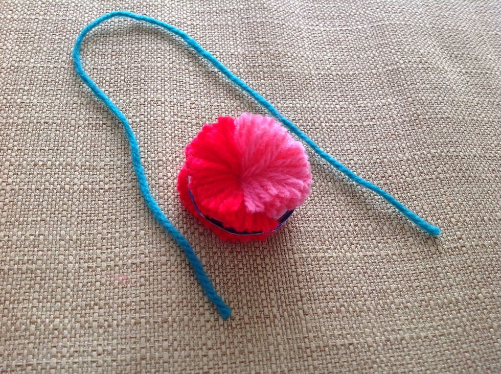 Cut a piece of string, the length is up to you, but don't cut it too short. I personally recommend somewhere from 15- 20 cm.