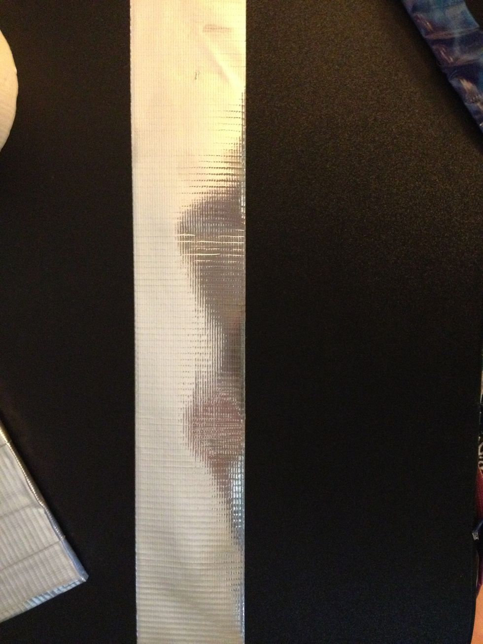 Cut a piece of tape a little more than twice the size of the largest part of your shape.