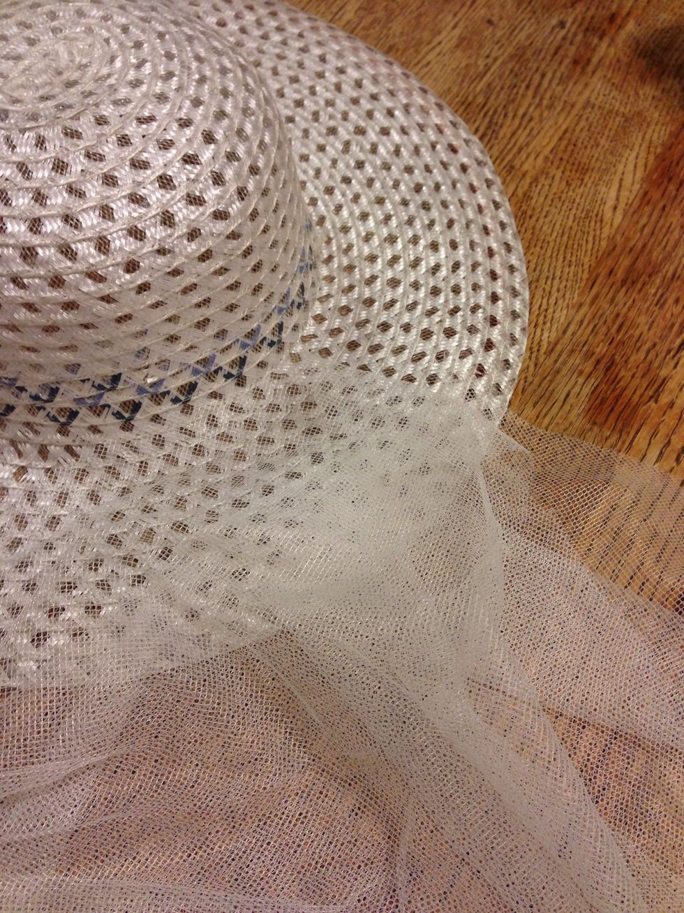 Cut a piece of tulle (I used an old net curtain from Goodwill) long enough to easily wrap around the brim of the hat. I then cut it with a 1m drop so it will hang below my shoulders.