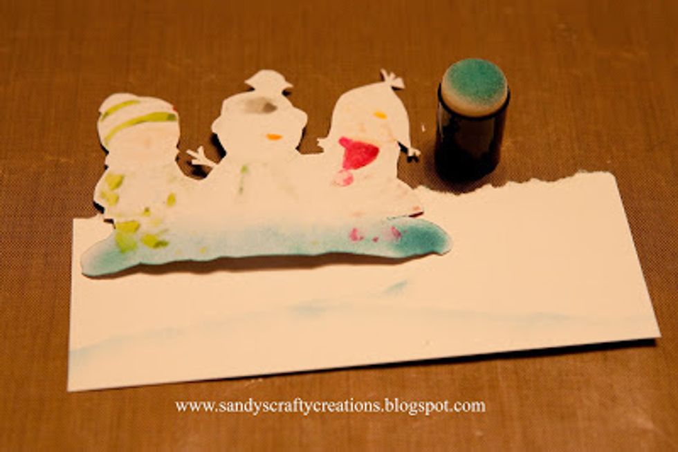 Cut a piece of white card stock to cover the front edge of the card and tear along the top edge. Flip your image over and use it as a pattern to ink snow drifts onto the white cardstock.