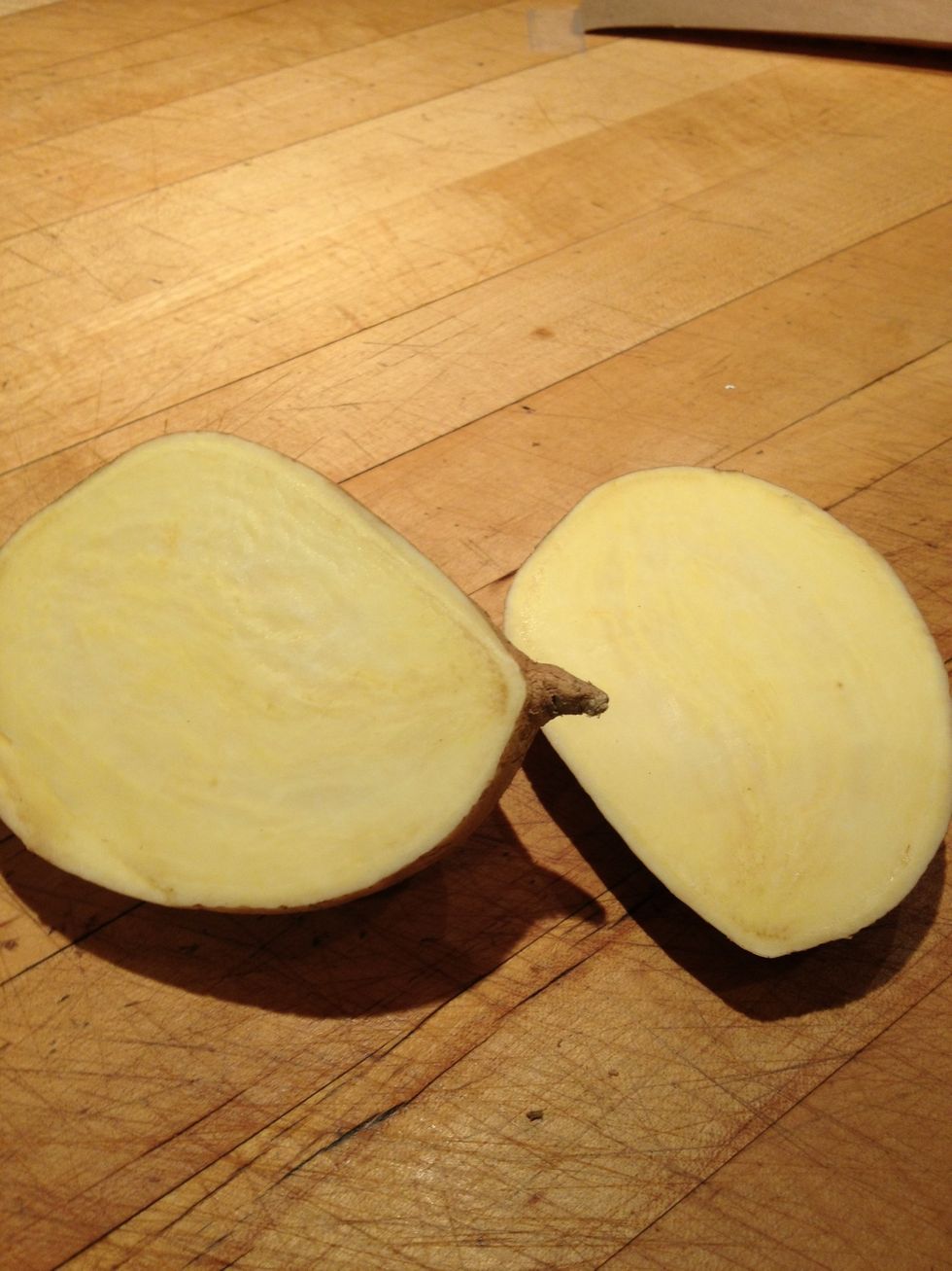 Cut a potato in half vertically. Be sure to select a potato with a wide enough surface. I am using white Japanese sweet potatoes since they looked like the best size for the project.