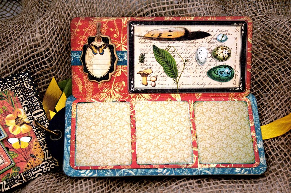 Cut a rectangle 7 1/2" x 6 3/4" & fold in half so that it is 7 1/2" x 3 5/8".   Ink, round the corners & glue the back flap to the 3rd tag.  Decorate the inside with photo mats, chipboard, flowers.