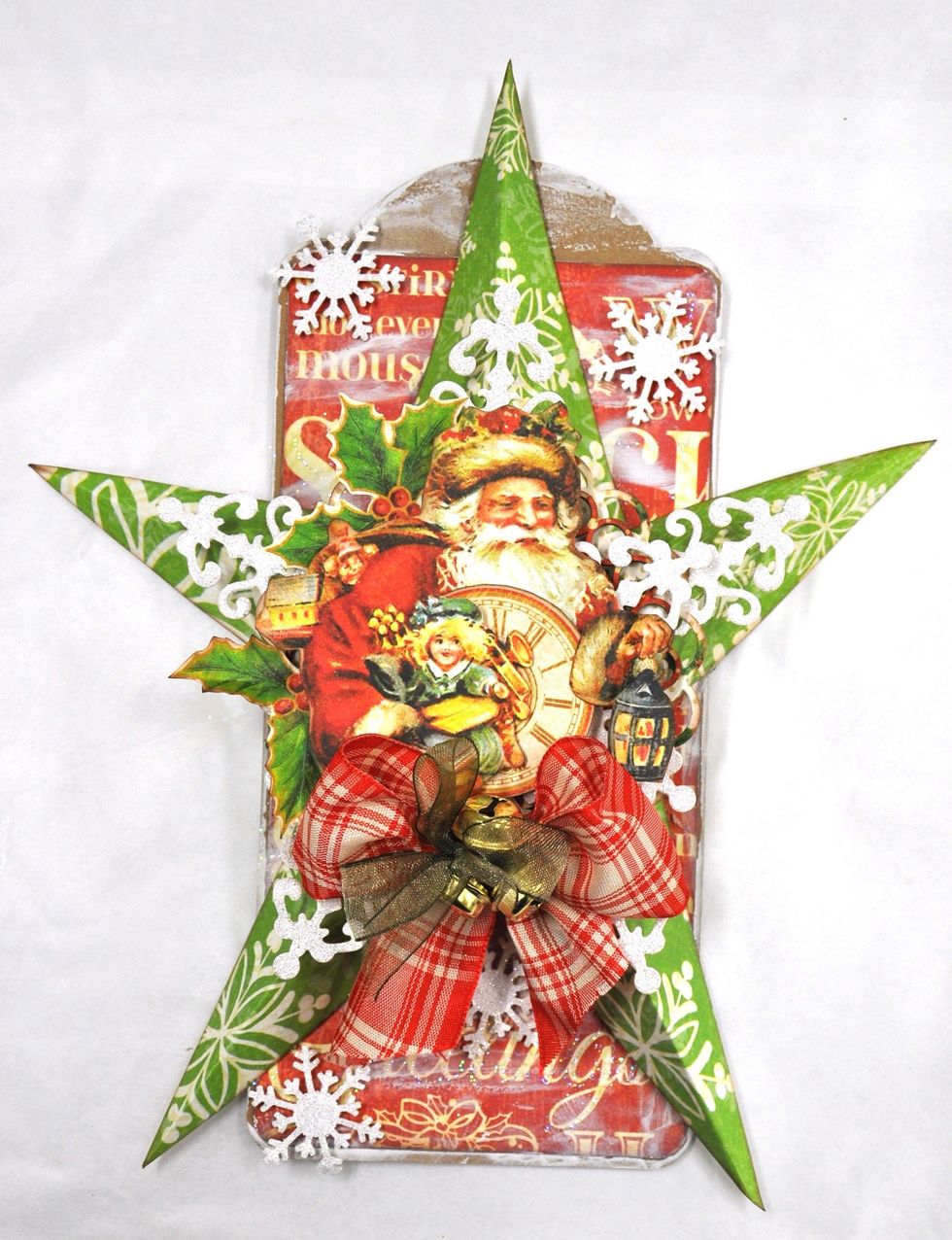 Cut a second snow flake die, cut the long points off and glue one onto each star under the circles. Add some small snowflakes to the tag. Add some ribbon and bells to finish your Christmas Decoration.
