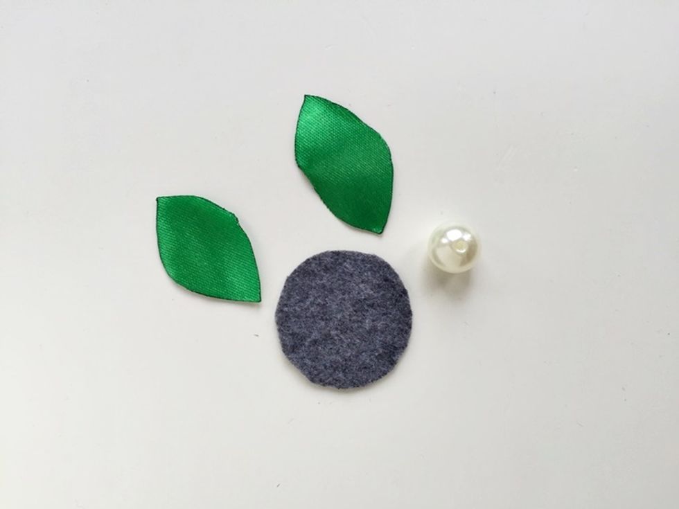 Cut a small piece of felt slightly bigger than the large ribbons center hole. Use green satin ribbons to make the leaves and also select a medium or large bead for the center for the flower.