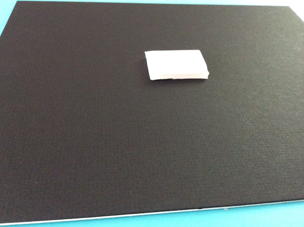 Cut a small piece of foam board, 1" x 1" approximately. Glue this to the center of the colored mat board.