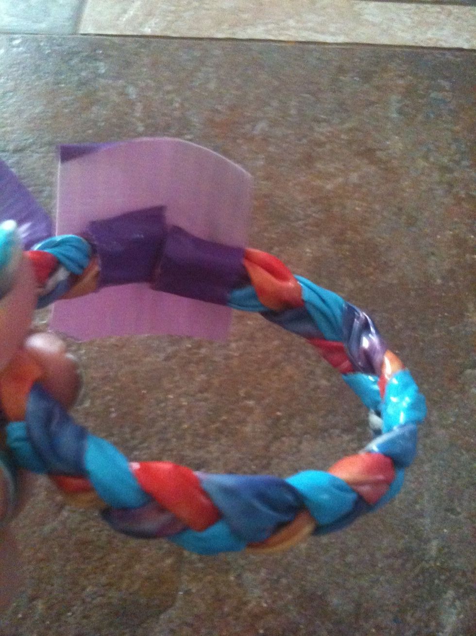 Cut a strip a little longer than the ones you used to tie the ends off of your braid. Make the ends of your bracelet come together and tape them so that they stay together