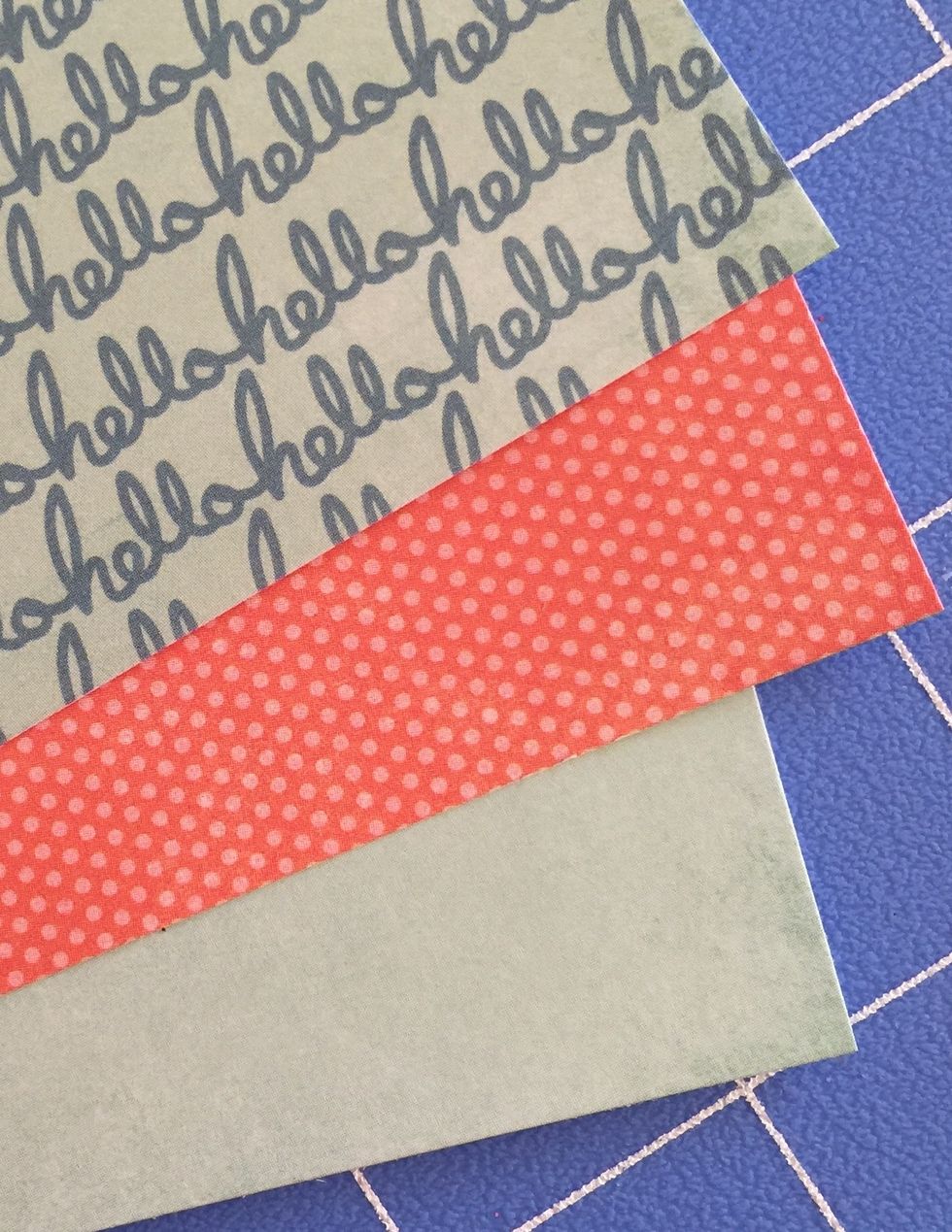 Cut a strip measuring 1 1/4 x 5 1/2 from the blue "hello" paper. Distress Edges. Adhere to the top edge of the orange paper. Adhere it so that one inch extends from the orange paper.