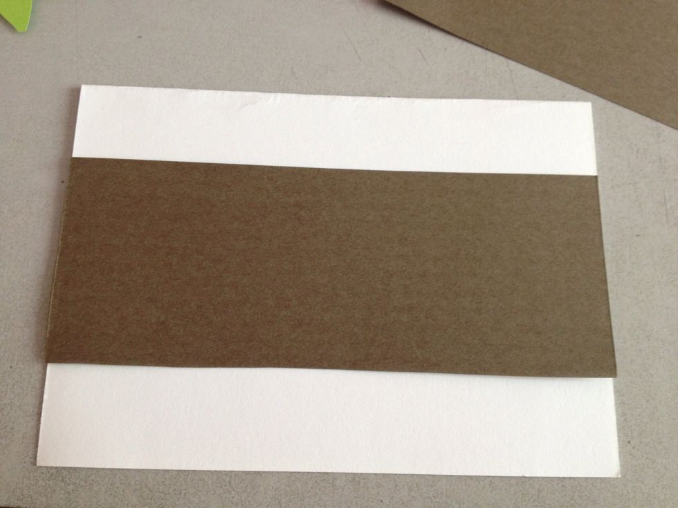 Cut a strip of coloured paper so that it fits the entire width of the card. You can do so by measuring the exact length of the width. Glue down.