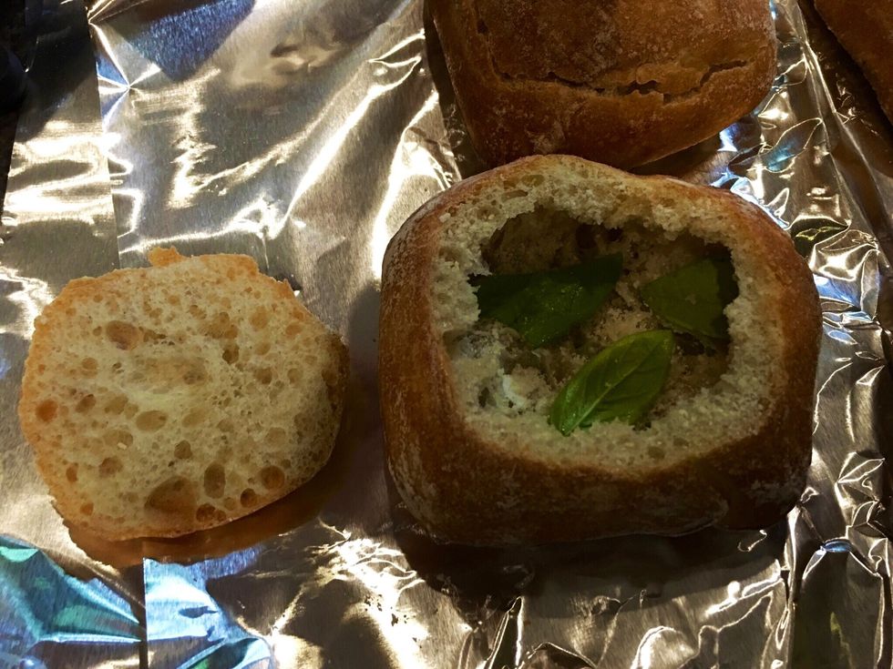 Cut a thin layer off the top of the rolls and remove enough bread to fit a large egg, ham and cheese in each. Sprinkle grated cheese and fresh chopped basil inside.