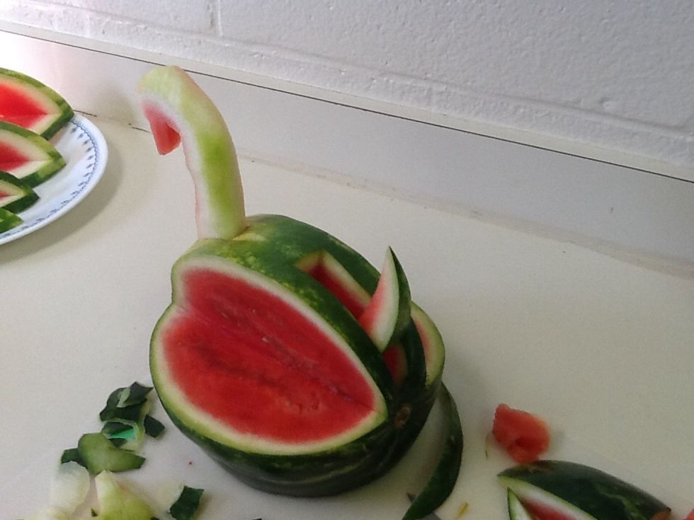 Cut a triangle out from about midway to just above the wing cuts with the point facing down. The cut the red portion off of the triangle to give it a curve. Make sure it fits back in the hole upright.