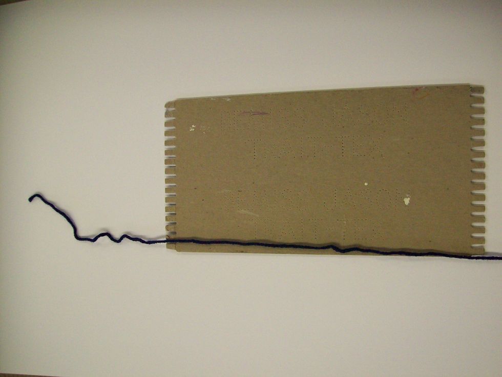 Cut a wingspan length of yarn. Lay it so the end of the yarn lays between the 1st and 2nd tooth of the loom. About 8 inches of yarn should be hanging over the edge.