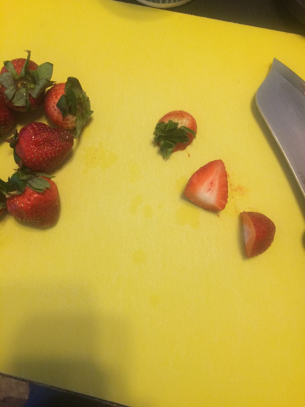 Cut about 1/2 cup of strawberries in half after rinsing, place in cup