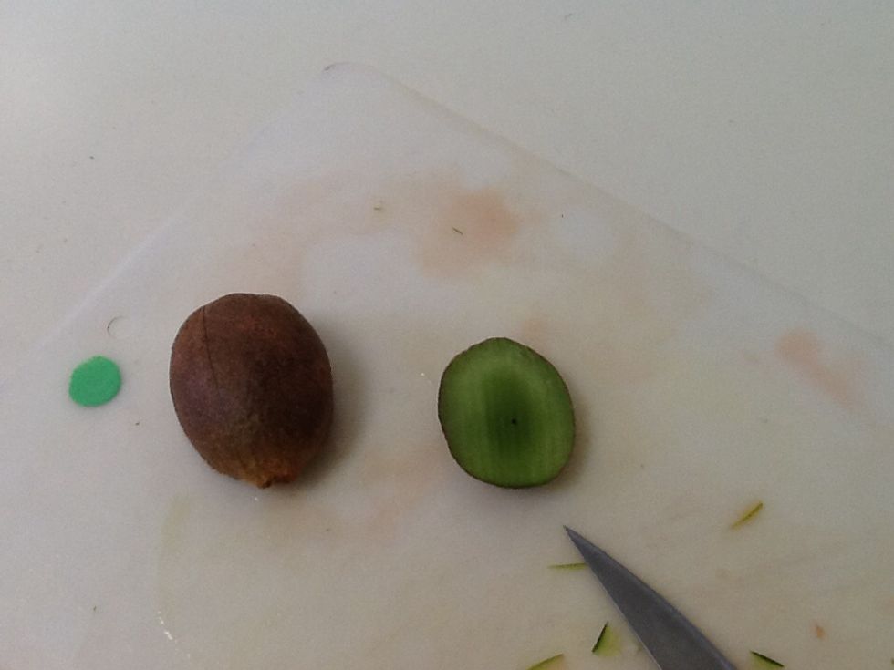 Cut about 1/5 off the side. make sure that it is the wider side of the kiwi if you have and oval shaped kiwi.