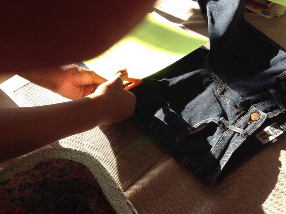 Cut across the jeans horizontally about 1 inch from the crotch.