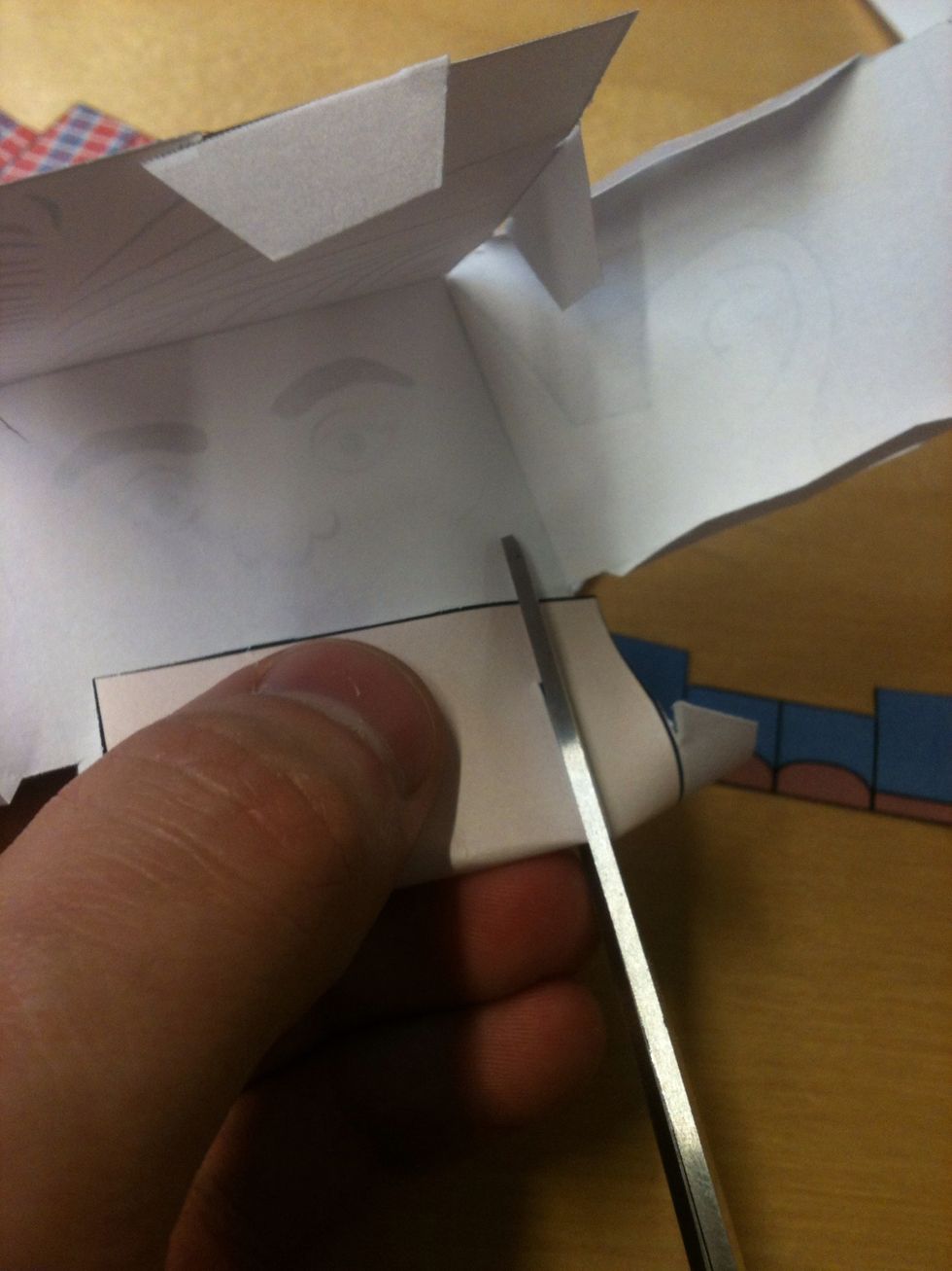 Cut along the black pair of lines on the top and bottom of the head and on the bottom of the upper body.