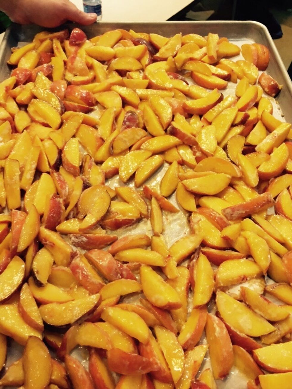 Cut and slice peaches onto a sheet tray. Lightly coat with flour, cornstarch & sugar.