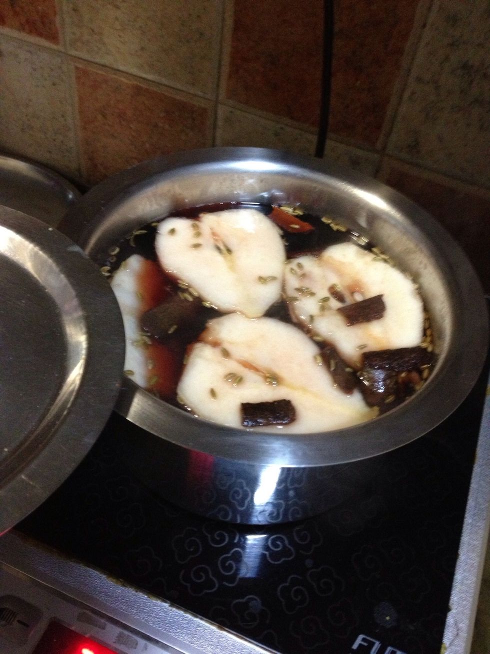Cut and slice the pears in two halves and dunk them in. Lower the heat and put the lid. Cook for 15-20 mins or till they're done. Leave the pears in the liquid after turning off the heat.